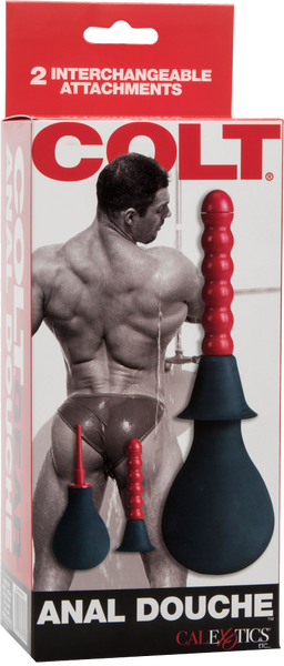 The image shows the packaging of the COLT Anal Douche™ with a muscular man on it holding the product. The box highlights features such as '2 interchangeable attachments' and 'EZ squeeze bulb'.